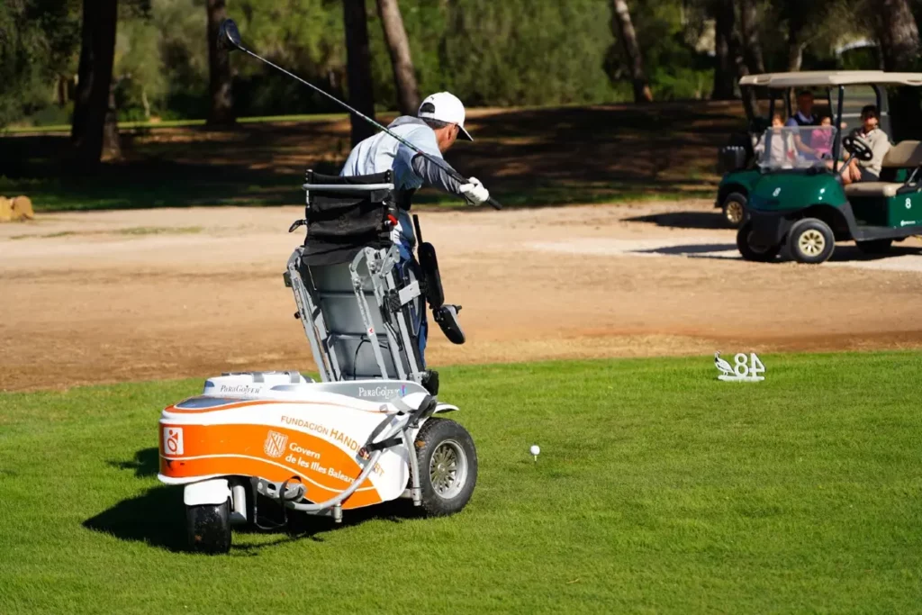 Golfer utilizing a ParaGolfer to stand up and take the swing on the golf course.