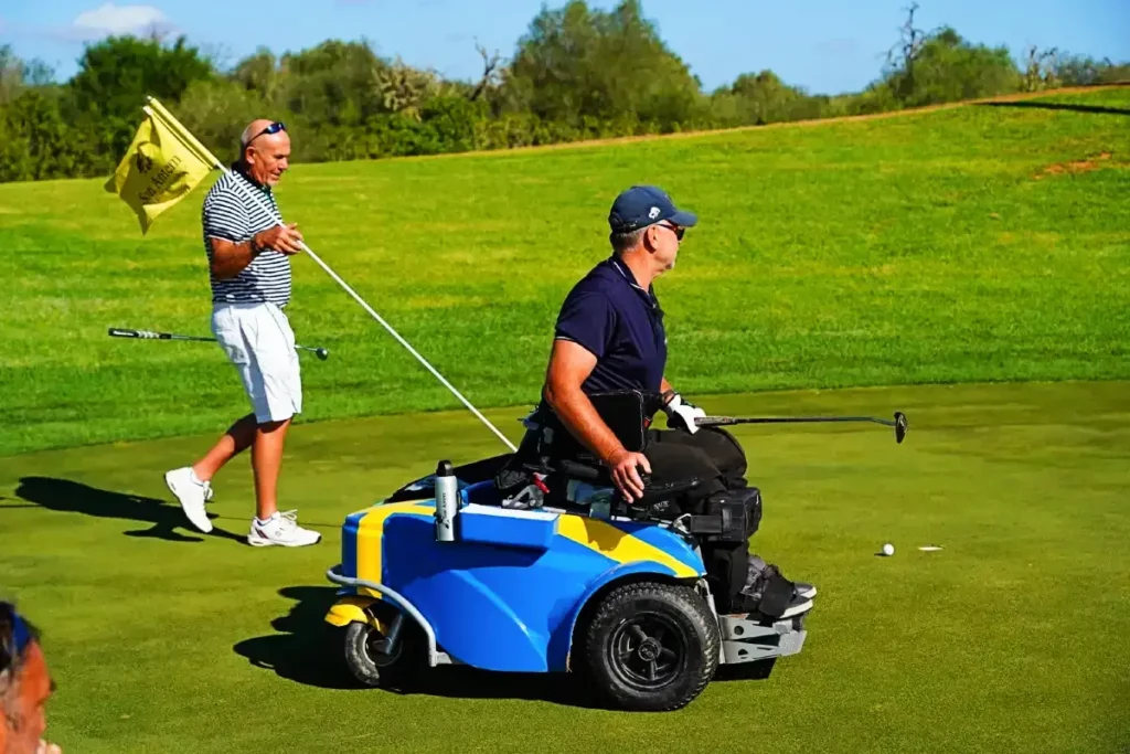 Golfer using a blue ParaGolfer to golf with a man in the background holding the flagstick.