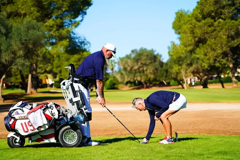 Golfer utilizing a ParaGolfer to stand up and take the swing on the golf course.