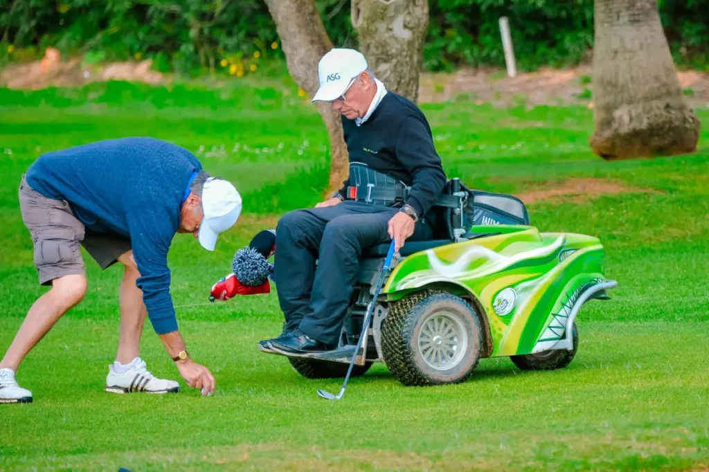Golfer using a ParaGolfer with a caddy placing a tee and ball