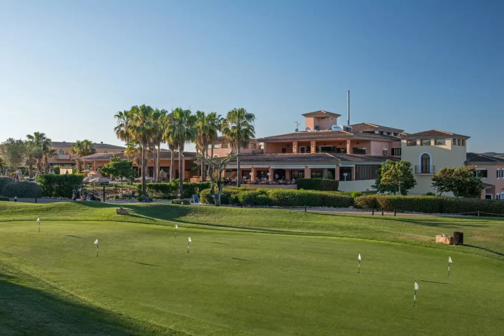 Scenic view of Son Antem East Golf Course with palm trees and clubhouse.